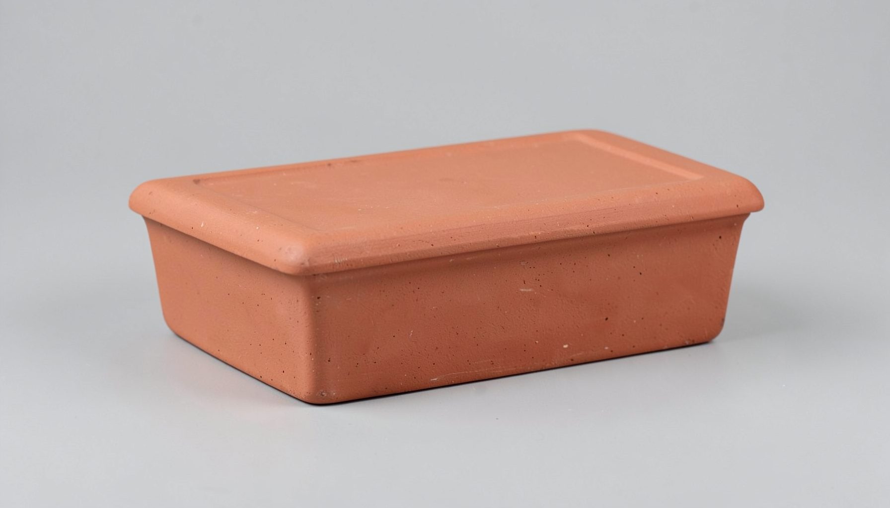A rectangular lidded clay box with subtle surface texture, shown on a neutral studio background